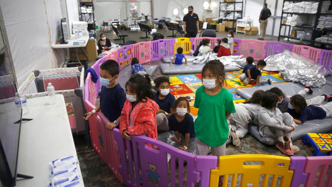 Unaccompanied migrant minors aged 3 to 9, watch a television monitor inside a playpen at the U.S. Customs and Border Protection facility, the main detention center for unaccompanied children in the Rio Grande Valley, in Donna, Texas, on March 30, 2021.