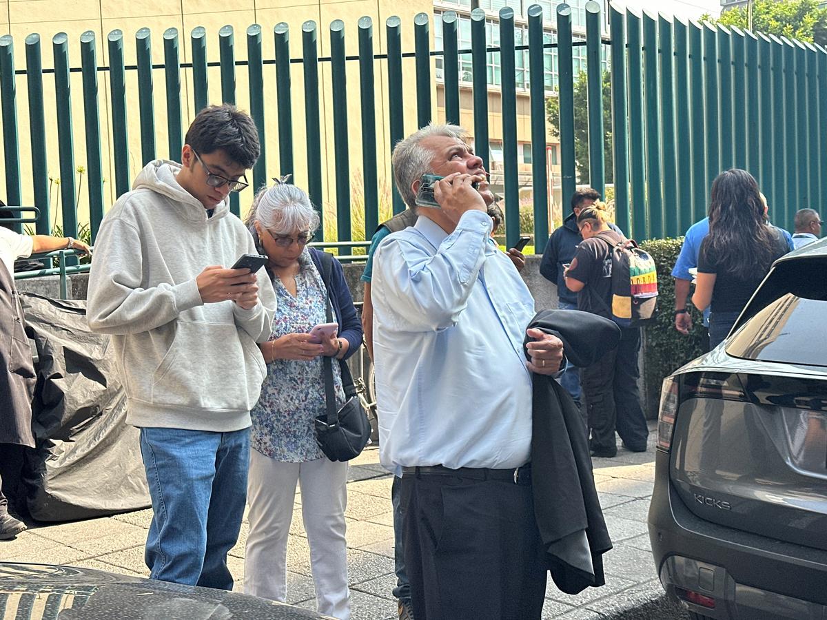 People wait outside their homes and buildings after an alarm sounded warning of a tremor, in Mexico City, Mexico, May 4 ,2026. REUTERS/Henry Romero