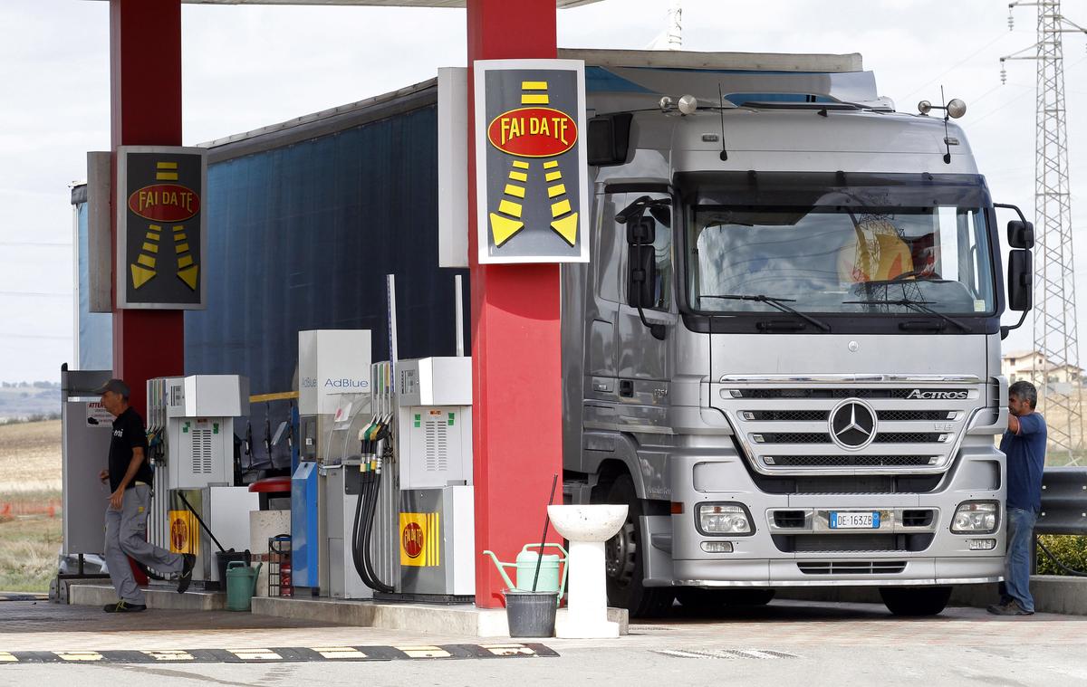 An attendant prepares to refuel a truck at a petrol station in Viterbo, north of Rome September 25, 2012. In car-mad Italy, record-high petrol prices are changing the motoring habits of a lifetime. Prime Minister Mario Monti's decision to hike petrol taxes to rake in much-needed revenue has pushed up fuel prices by 15 percent over the last year, making them the highest in Europe. Prices at the pump recently broke through 2 euros per litre in some stations, a psychological threshold for car enthusiasts in the home of gas-guzzling sportscar marques such as Ferrari and Lamborghini. REUTERS/Giampiero Sposito (ITALY - Tags: BUSINESS TRANSPORT ENERGY)