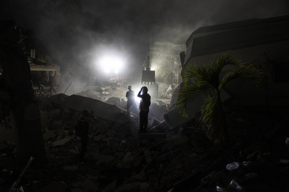 Rescue workers search under lights at the Gabarra building that collapsed in last week's earthquakes in La Guaira, Venezuela, on Monday, June 29, 2026. It has been six days since devastating twin earthquakes flattened entire residential neighborhoods in Venezuela, and dozens of new bodies are still being hauled out of the rubble. (Fabiola Ferrero/The New York Times)