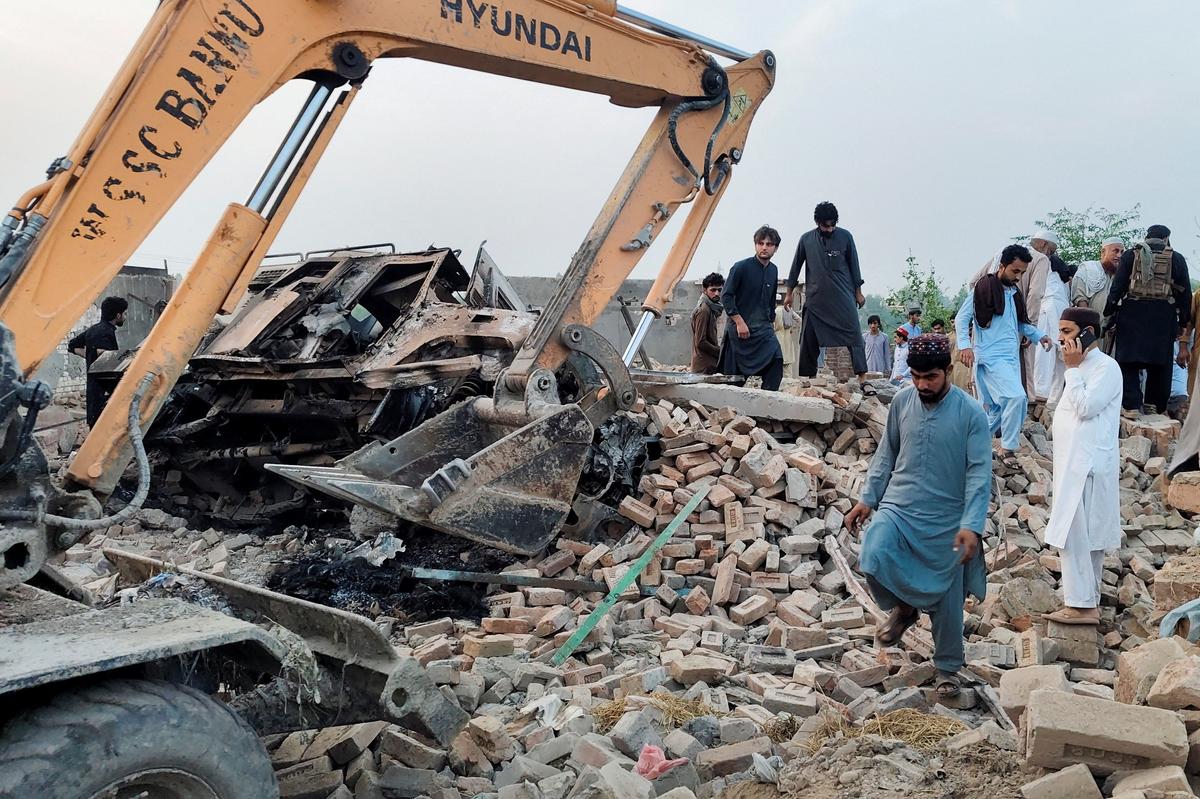 Residents gather on the rubble of a damaged police post after a car bombing in Bannu, Khyber Pakhtunkhwa province, Pakistan May 10, 2026. Picture taken with a mobile phone. REUTERS/Ehsan Khattak