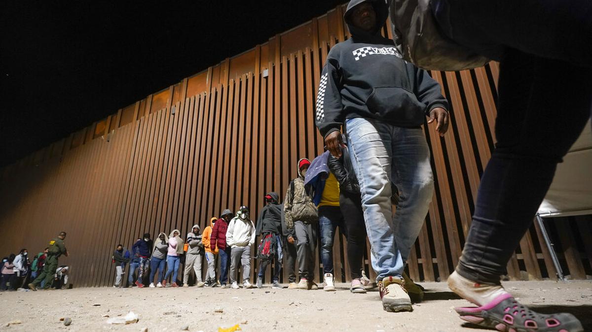Un grupo de migrantes, en su mayoría de Cuba, hacen fila para abordar un autobús después de cruzar la frontera desde México y entregarse a las autoridades para solicitar asilo el jueves 3 de noviembre de 2022, cerca de Yuma, Arizona. (Foto AP/Gregory Bull)