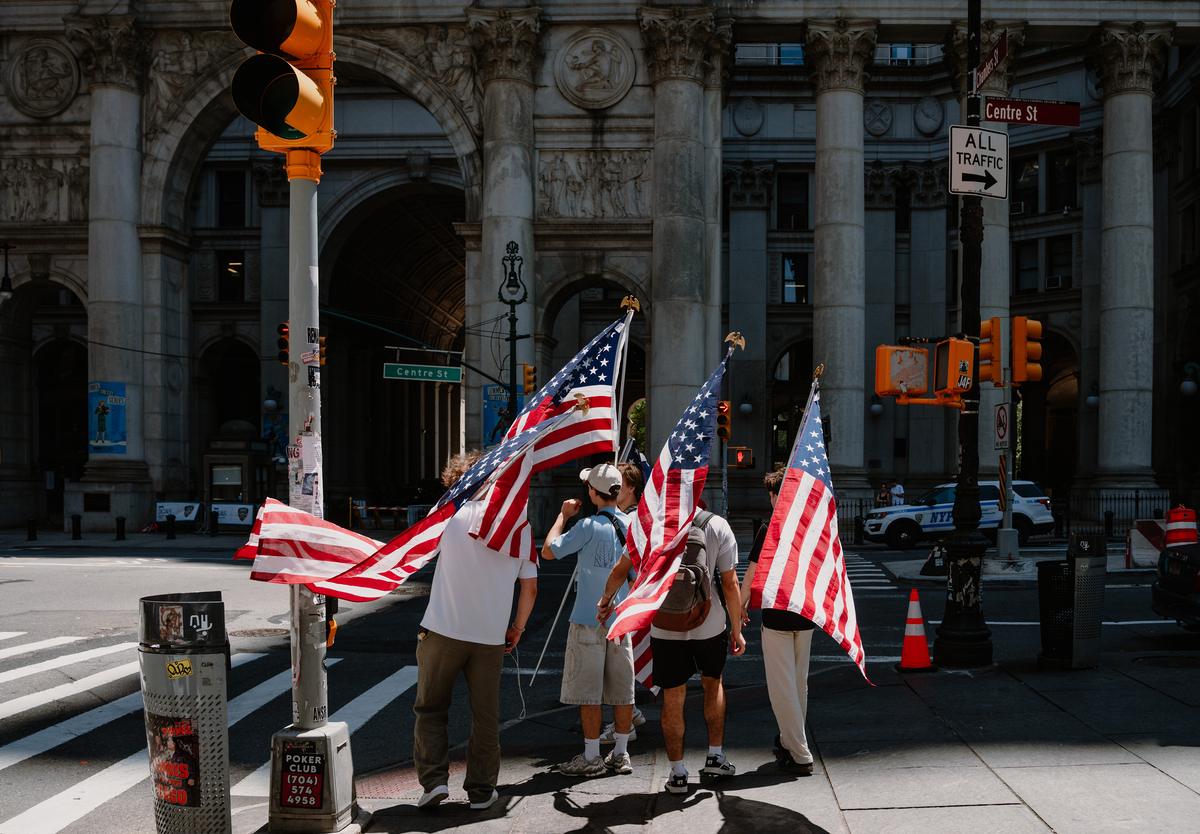 A group carrying large American flags walks past City Hall in New York, July 4, 2026. America celebrates the 250th anniversary of its independence today, with people from one end of the country to the other marking the milestone with fireworks, parades and concerts. (Lucia Vazquez/The New York Times)