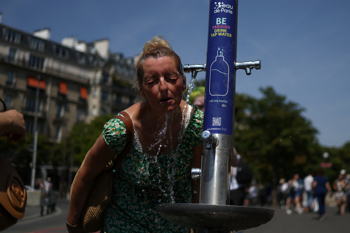 A woman cools off in a public fountain near the Place du Trocadero during high temperatures amid a heatwave in Paris, France, June 27, 2026. REUTERS/Tom Nicholson
