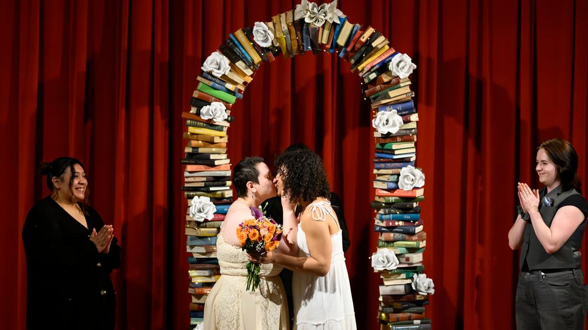 Angela and Javitha Russo share their first kiss Saturday, April 25, 2026, at Minneapolis Central Library. Five couples were married in the Pohlad Hall to celebrate National Library Week. (Aaron Lavinsky/The Minnesota Star Tribune/TNS)