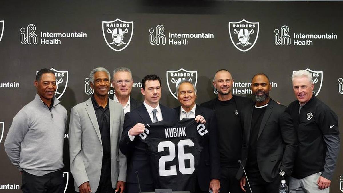  Feb 10, 2026; Henderson, NV, USA; Las Vegas Raiders coach Klint Kubiak (center) poses at introductory press conference at Intermountain Health Performance Center. From left: Marcus Allen, Mike Haynes, Howie Long, Kubiak, general manager John Spyktek, Charles Woodson and Rich Gannon. Mandatory Credit: Kirby Lee-Imagn Images | Kirby Lee-Imagn Images 
