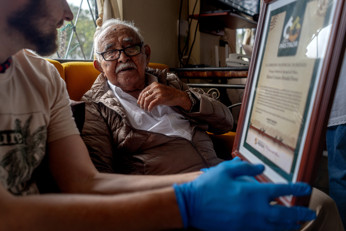 The farmer and snake collector Manuel Genaro Peñafiel, right, is presented with a plaque by the American scientist Alex Bentley at Peñafiel's home in Mera, Ecuador, on April 6, 2026. Bentley says he was "blown away" by Peñafiel's collection. (Johanna Alarcon/The New York Times)