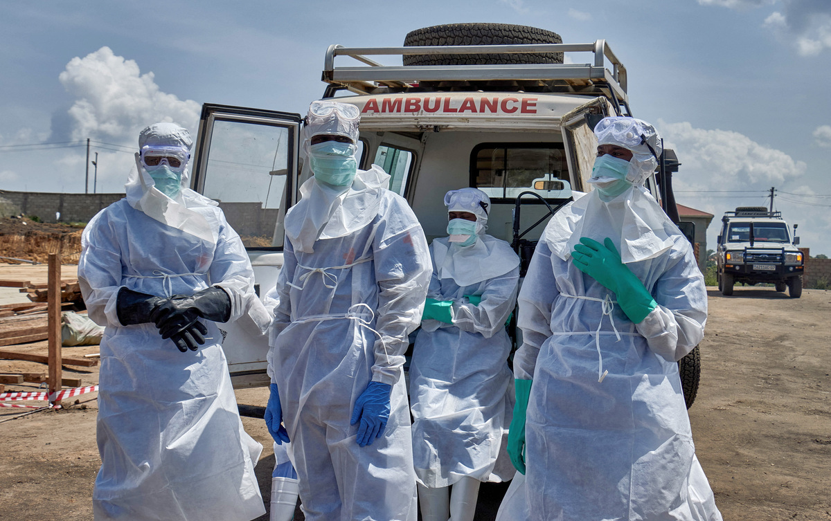 Red Cross workers wearing personal protective equipment (PPE) gather after handling the coffin of a man who died of Ebola virus, as aid agencies intensify efforts to contain the Ebola outbreak caused by the Bundibugyo virus, in Bunia, Ituri province, Democratic Republic of Congo, June 10, 2026. REUTERS/Gradel Muyisa Mumbere
