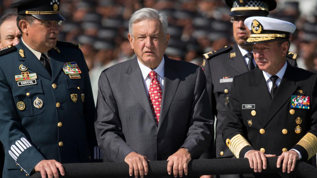 El presidente de México, Andrés Manuel López Obrador, flanqueado por el secretario de Defensa, el general Luis Crescencio Sandoval, a la izquierda, y el secretario de Marina, José Rafael Ojeda, examina a las tropas de la Guardia Nacional mientras se presenta la nueva fuerza durante una ceremonia, en la Ciudad de México, el 30 de junio de 2019.