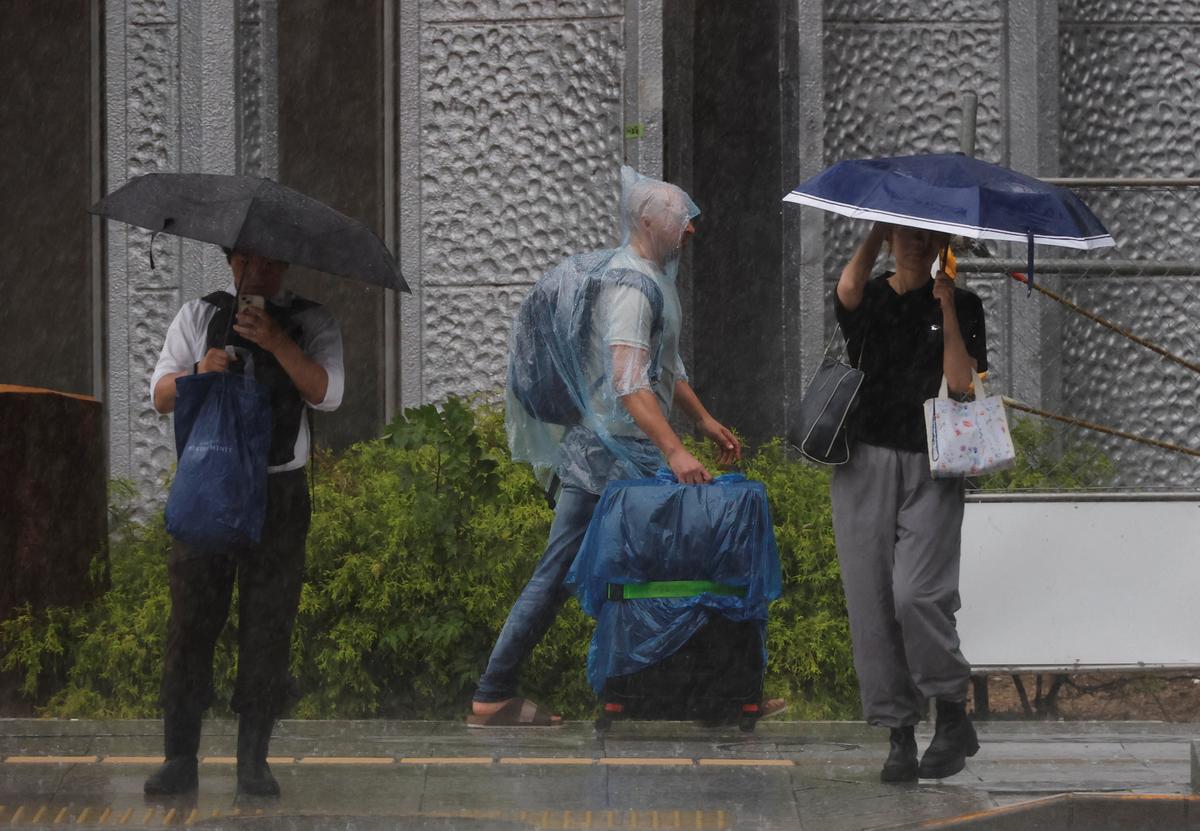 A tourist wearing a rain coat walks through heavy rain brought by Typhoon Jangmi in Tokyo, Japan, June 3, 2026. REUTERS/Kim Kyung-Hoon