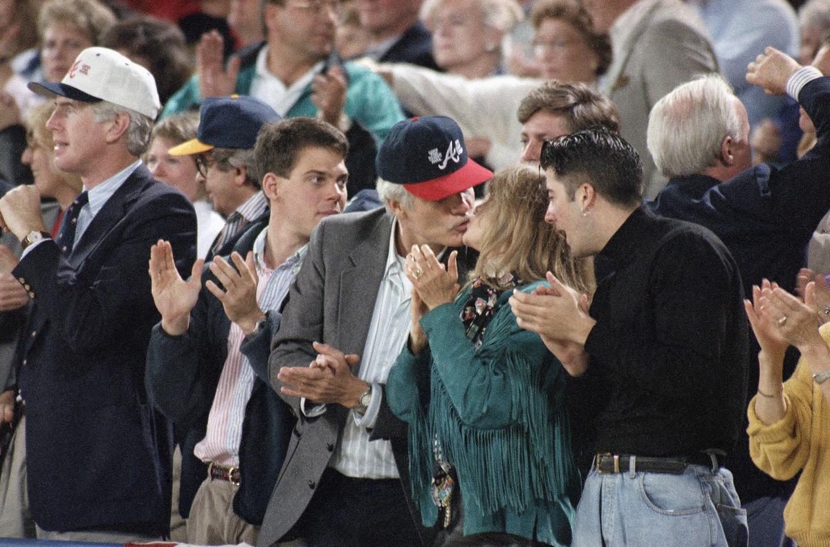  Atlanta Braves owner Ted Turner leans to kiss his wife, Jane Fonda during the World Series game in Atlanta, Oct. 17, 1992. (AP Photo/John Swart) 