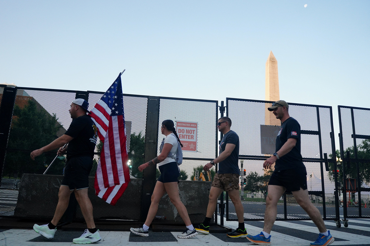 People walk past security barricades near the Washington Monument ahead of Fourth of July celebrations, marking the 250th anniversary of U.S. Independence, in Washington, D.C., U.S., July 4, 2026. REUTERS/Nathan Howard