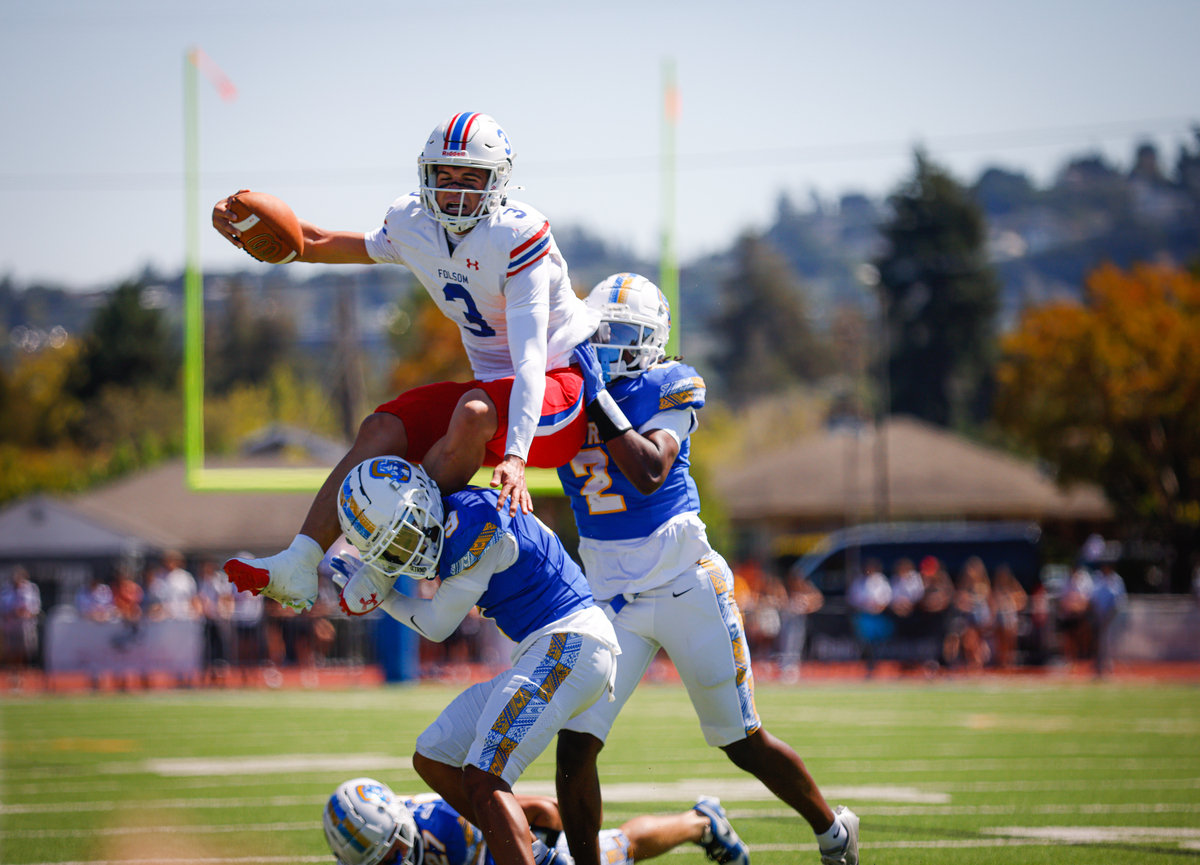 Folsom's Ryder Lyons (3) jumps over Serra's Aidan Labrador (9) and Serra's Aaron Maier (2) in the first quarter at Serra High School in San Mateo on Saturday.