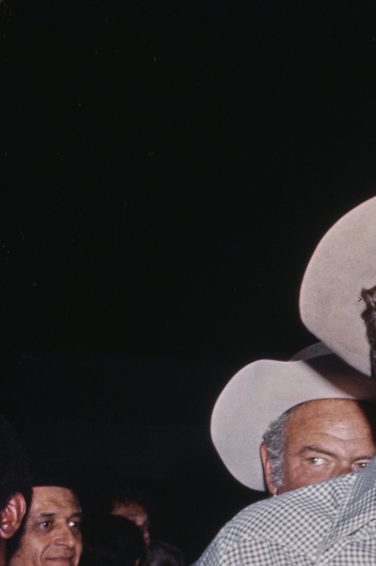 American actor Tom Selleck, wearing an open collar checked shirt, jeans and a cowboy hat, among guests attending an event, United States, circa 1980.Michael Ochs Archives/Getty Images