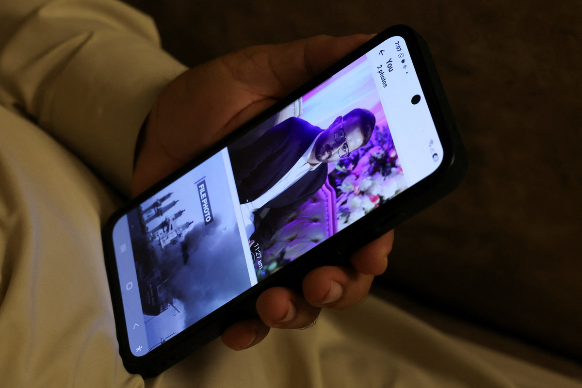 Ghulam Nabi Bahrani holds a mobile phone showing a picture of his son-in-law, Faisal Jatoi, who was the co-pilot (First Officer) of the K2 Airways Boeing 737 cargo plane that crashed in the Arabian Sea, at his home in Karachi, Pakistan, July 8, 2026. REUTERS/Akhtar Soomro