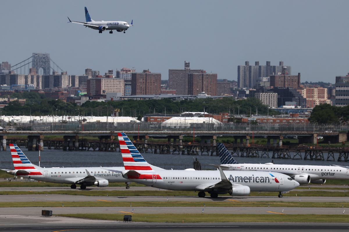 Planes cue on the runway for takeoff as another lands at New York's LaGuardia airport, where closure of one of the runways due to a sinkhole on Wednesday is expected to continue until early Saturday, snarling flights for the busy Memorial Day travel period in New York City, U.S., May 22, 2026. REUTERS/Shannon Stapleton