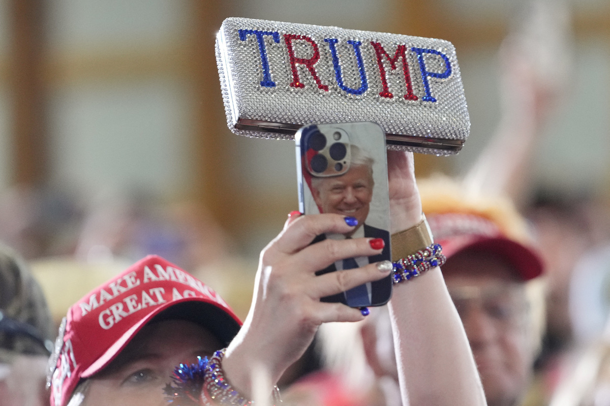 A supporter of U.S. President Donald Trump wearing a red MAGA hat uses a mobile phone with a case featuring a picture of Trump, during an event at Custer Farms in Chippewa Falls, Wisconsin, U.S., June 5, 2026. REUTERS/Nathan Howard