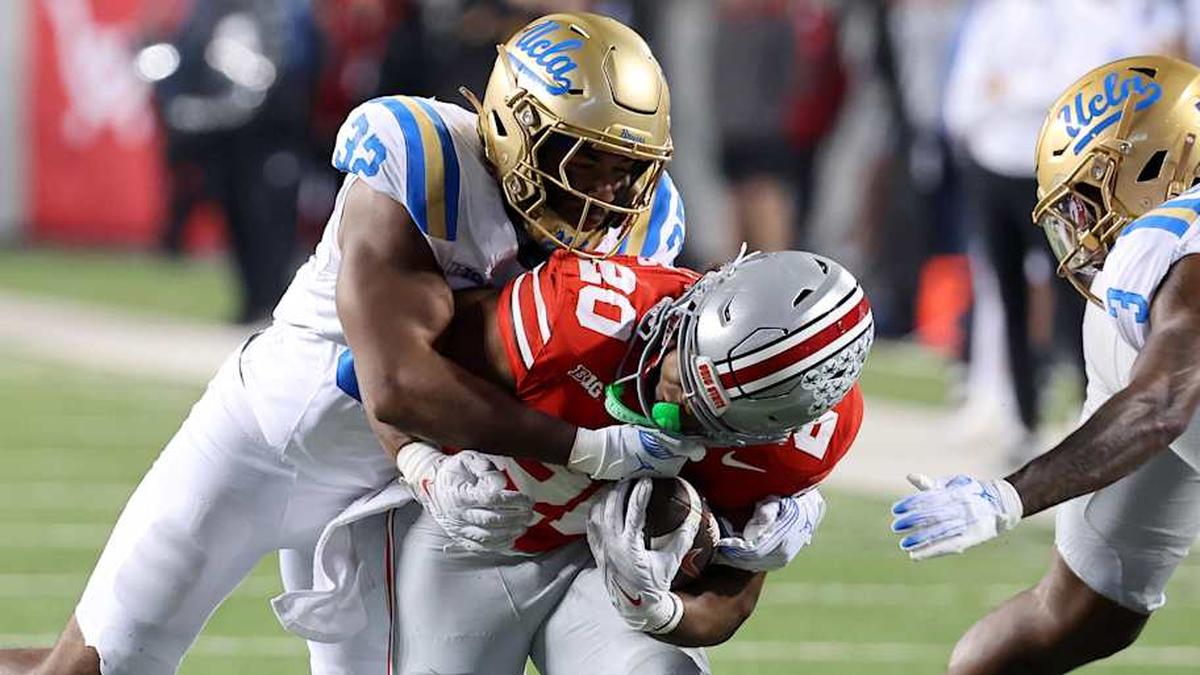  Nov 15, 2025; Columbus, Ohio, USA; Ohio State Buckeyes running back James Peoples (20) runs the ball as UCLA Bruins linebacker Isaiah Chisom (32) makes the tackle during the fourth quarter at Ohio Stadium. Mandatory Credit: Joseph Maiorana-Imagn Images | Joseph Maiorana-Imagn Images 