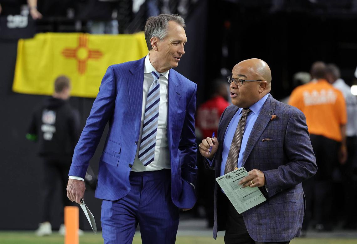  LAS VEGAS, NEVADA - NOVEMBER 12: NBC Sunday Night Football color commentator Cris Collinsworth (L) and play-by-play announcer Mike Tirico walk onto the field before a game between the New York Jets and the Las Vegas Raiders at Allegiant Stadium on November 12, 2023 in Las Vegas, Nevada. (Photo by Ethan Miller/Getty Images) 