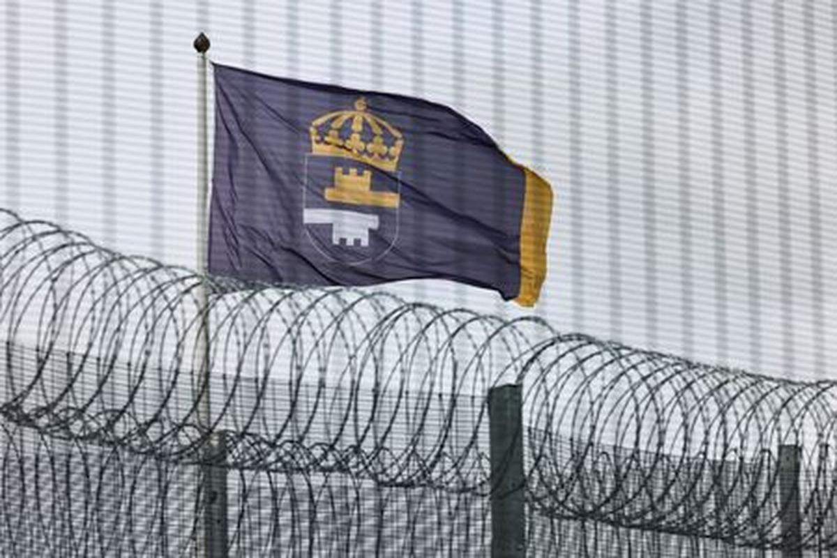 The flag of the Swedish Prison and Probation Service flutters behind the fence surrounding Rosersberg Prison near Stockholm, Sweden, May 25, 2026. REUTERS/Tom Little