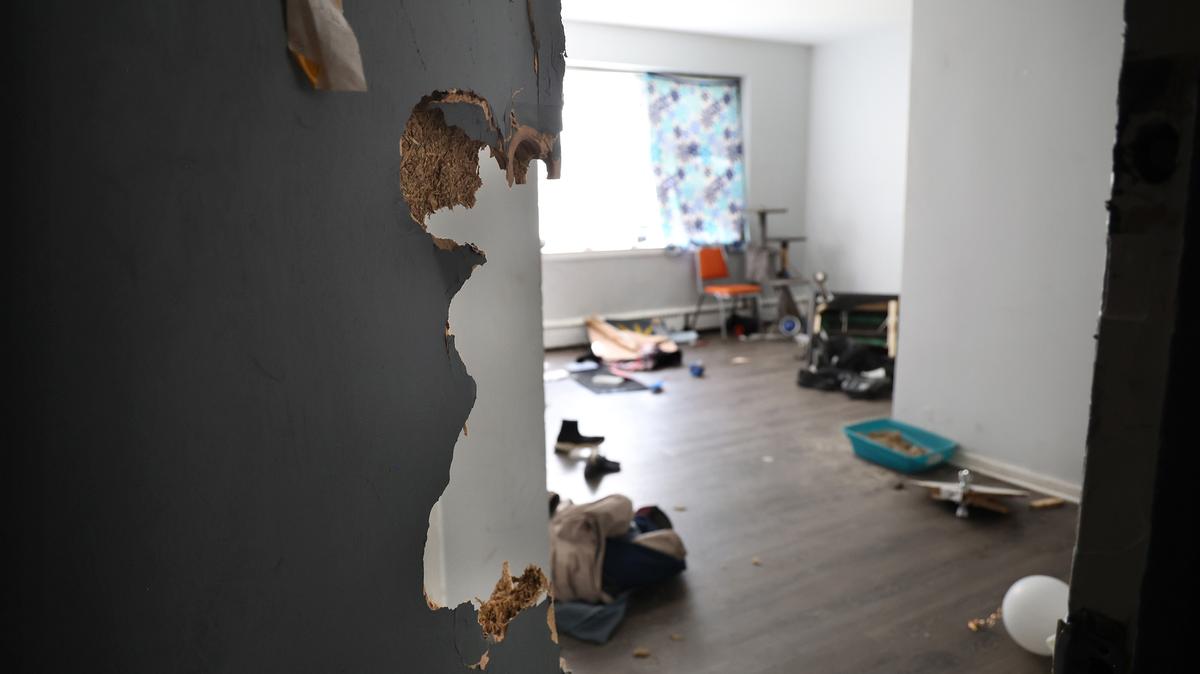 An apartment door at 7500 S. South Shore Drive in Chicago is left open and damaged on Oct. 2, 2025, with clothing and other items on the floor days after federal agents descended on the building in an early-morning raid. (Antonio Perez/Chicago Tribune/TNS)