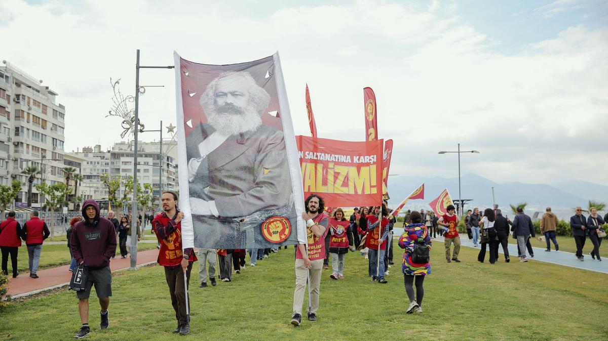 People march holding banners and a portrait of Karl Marx during a May Day rally in Izmir, Turkey, on May 1, 2026. May Day rallies were held across Turkey with workers, unions and political groups gathering in cities including Izmir, while authorities maintained a heavy security presence and carried out detentions in some locations. (Berkcan Zengin/Middle East Images/AFP/Getty Images/TNS)