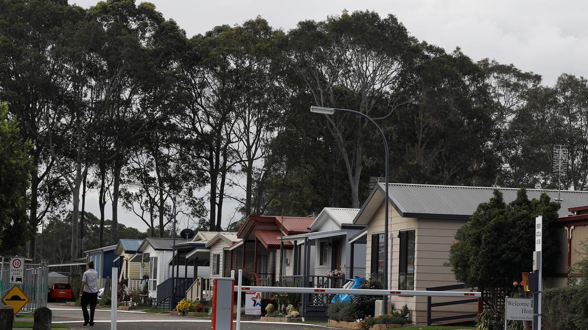 FILE PHOTO: A woman walk past houses in Nowra, Australia April 26, 2018. REUTERS/Edgar Su/File Photo