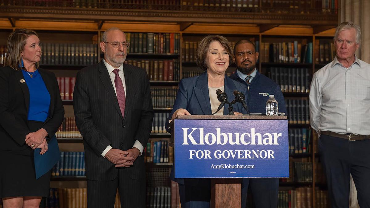 From left, Grand Rapids (Minn.) Mayor Tasha Connelly, former U.S. Attorney Andy Luger, Brooklyn Park Mayor Hollies Winston and former St. Paul Mayor Chris Coleman stand behind U.S. Sen. Amy Klobuchar, D-Minn., during a news conference May 3, 2026, in St. Paul, Minnesota. (Jerry Holt/The Minnesota Star Tribune/TNS)