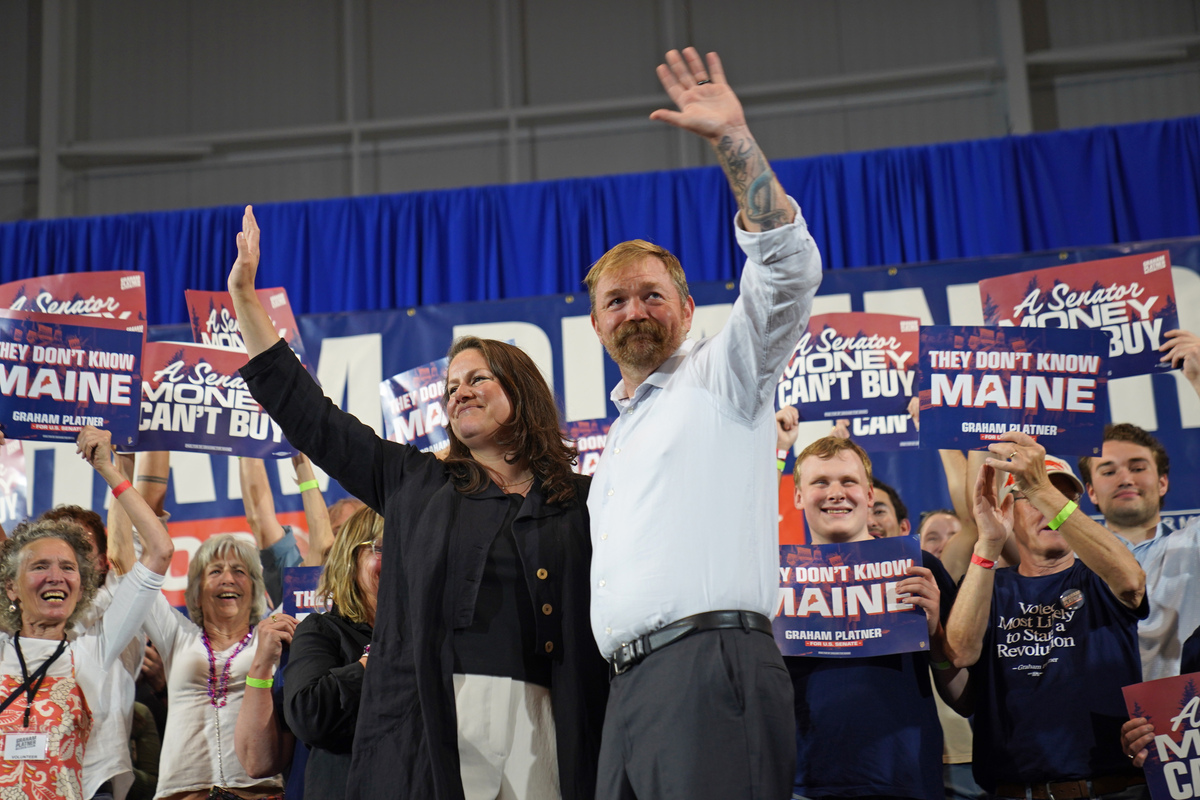 Graham Platner takes the stage at his election night watch party with his wife, Amy Gertner, after he won the Democratic nomination for Senate, in Blue Hill, Maine, on Tuesday, June 9, 2026. Platner quickly turned his populist message against Susan Collins, the Republican incumbent. (Sophie Park/The New York Times)