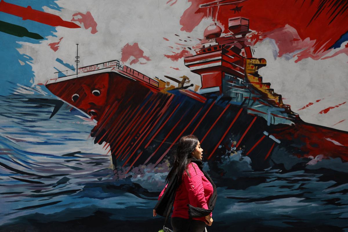 An Iranian woman walks next to a mural on a street in Tehran, Iran, May 6, 2026. Majid Asgaripour/WANA (West Asia News Agency) via REUTERS