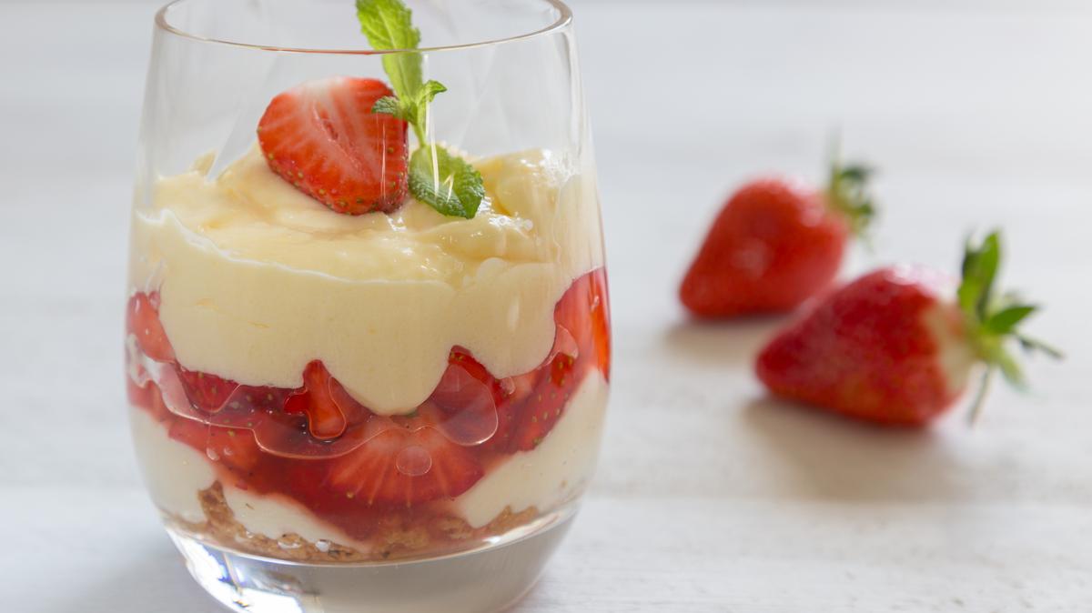 Vanilla pudding with tipsy strawberries on wood.