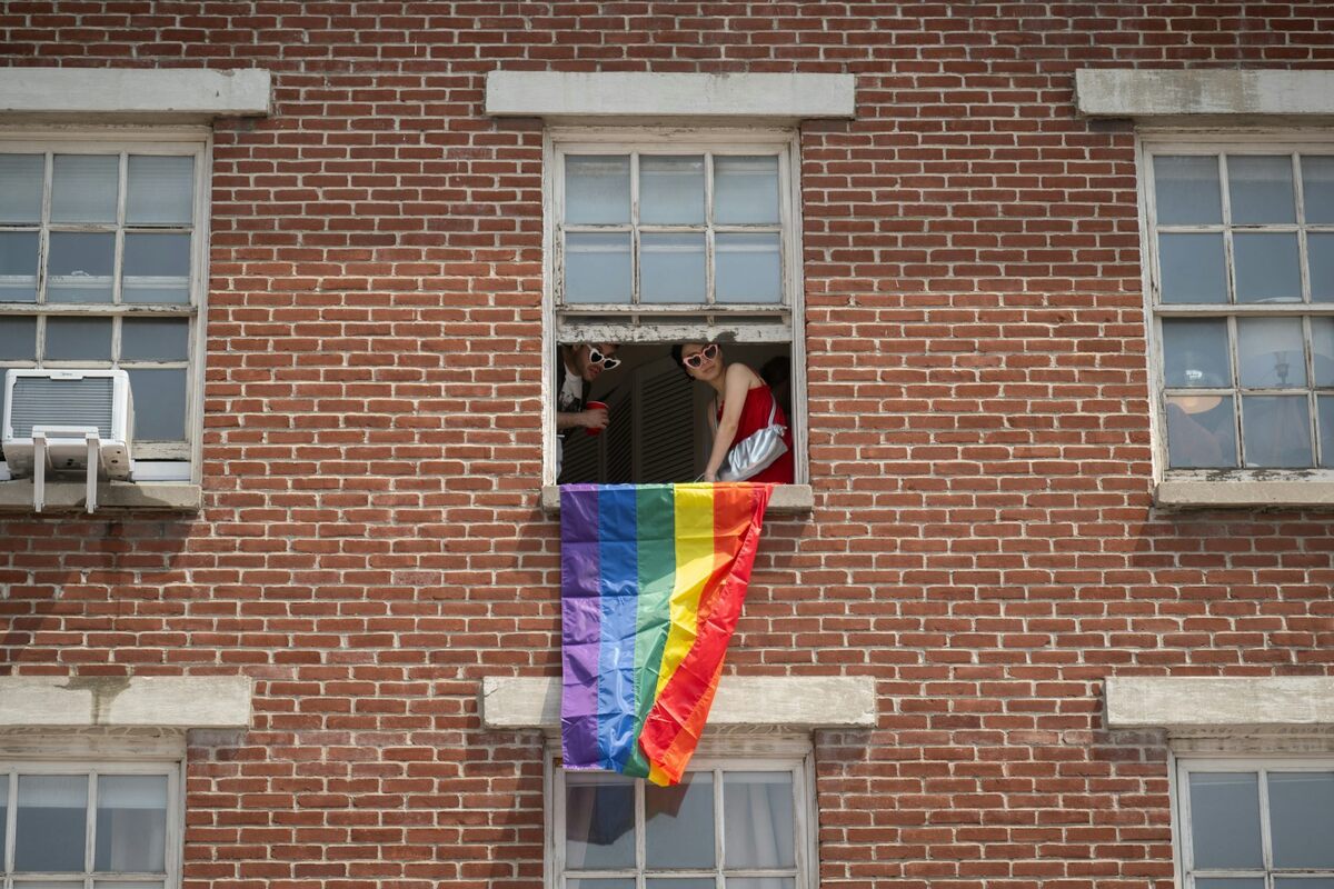  People drape a rainbow flag from a window during the 2026 New York City Pride March. Noam Galai/Getty Images 