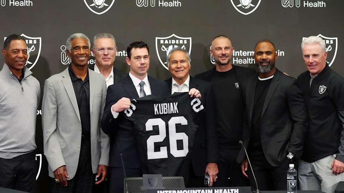  Feb 10, 2026; Henderson, NV, USA; Las Vegas Raiders coach Klint Kubiak (center) poses at introductory press conference at Intermountain Health Performance Center. From left: Marcus Allen, Mike Haynes, Howie Long, Kubiak, general manager John Spyktek, Charles Woodson and Rich Gannon. Mandatory Credit: Kirby Lee-Imagn Images | Kirby Lee-Imagn Images 