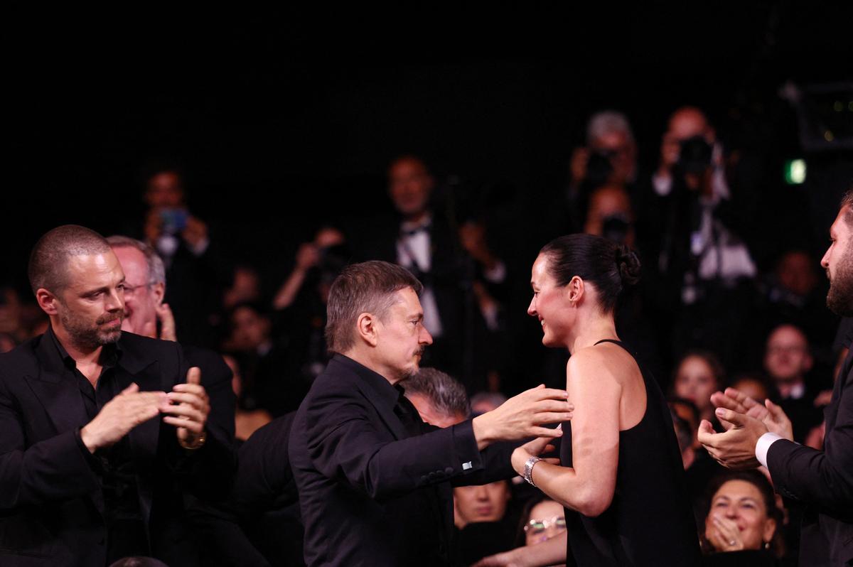 Cast members Sebastian Stan and Renate Reinsve stand as director Cristian Mungiu, winner of the Palme d'Or award for the film "Fjord", reacts during the closing ceremony of the 79th Cannes Film Festival in Cannes, France, May 23, 2026. REUTERS/Marko Djurica