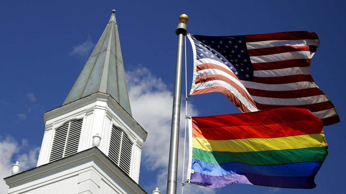 FILE - In this April 19, 2019 file photo, a gay pride rainbow flag flies along with the U.S. flag in front of the Asbury United Methodist Church in Prairie Village, Kan.