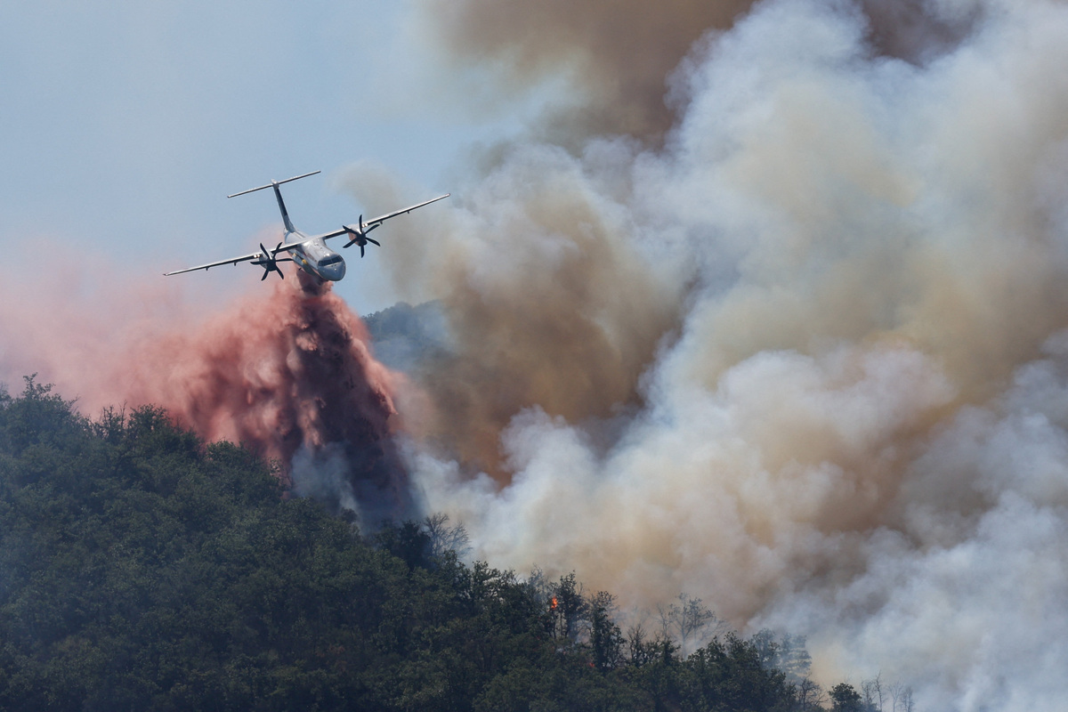 A firefighting plane drops water, following a wildfire in Ille-sur-Tet near Perpignan, France, July 6, 2026. REUTERS/Alexandre Dimou