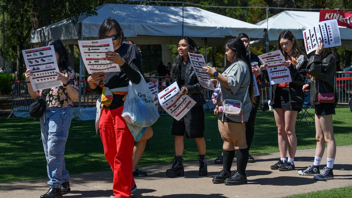 BTS fans look at merchandise leaflet while waiting in line to purchase merchandise before tonight’s concert at Stanford Stadium at Stanford, Calif., on Saturday, May 16, 2026. BTS will be performing three shows on May 16, 17, and May 19. (Jose Carlos Fajardo/Bay Area News Group)