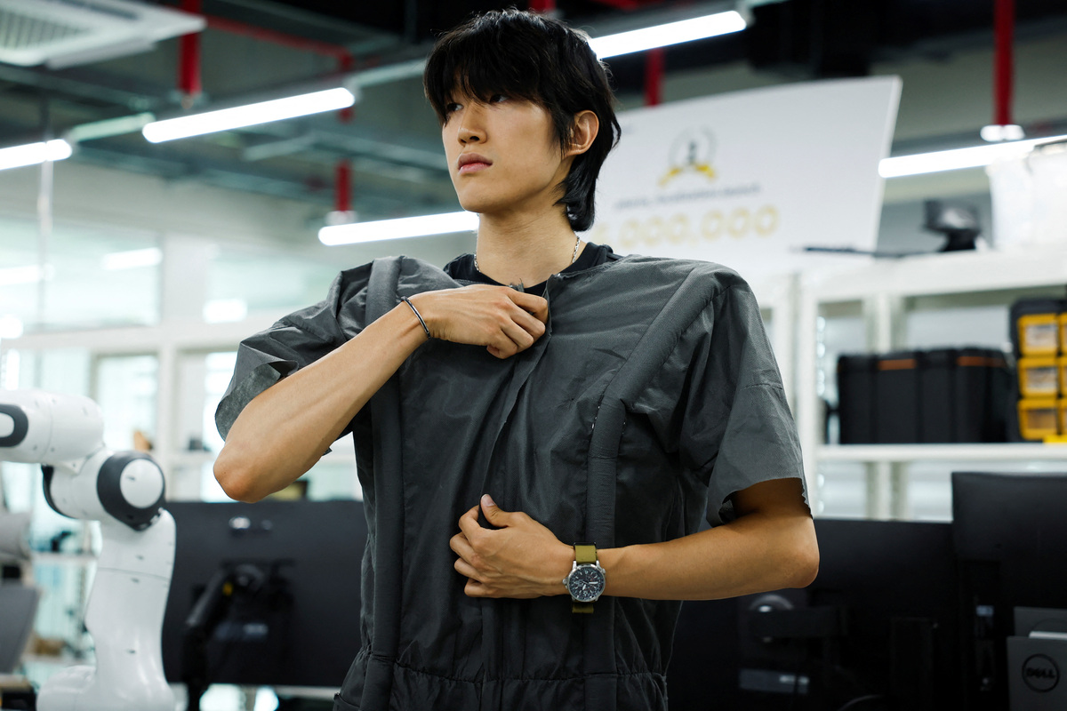 Hwang Jae Yun, a graduate student of Civil and Environmental Engineering at the Korea Advanced Institute of Science and Technology (KAIST), demonstrates wearing a self-dressing robot at KAIST in Daejeon, South Korea, July 14, 2026. REUTERS/Kim Soo-hyeon