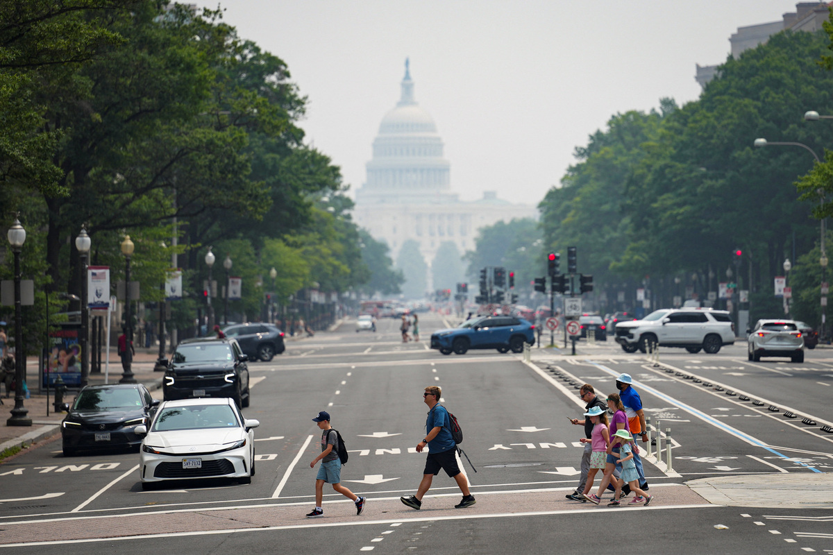 Pedestrians cross Pennsylvania Avenue near the U.S. Capitol in smoky conditions due to the Canadian wildfires, in Washington, D.C., U.S., July 17, 2026. REUTERS/Al Drago