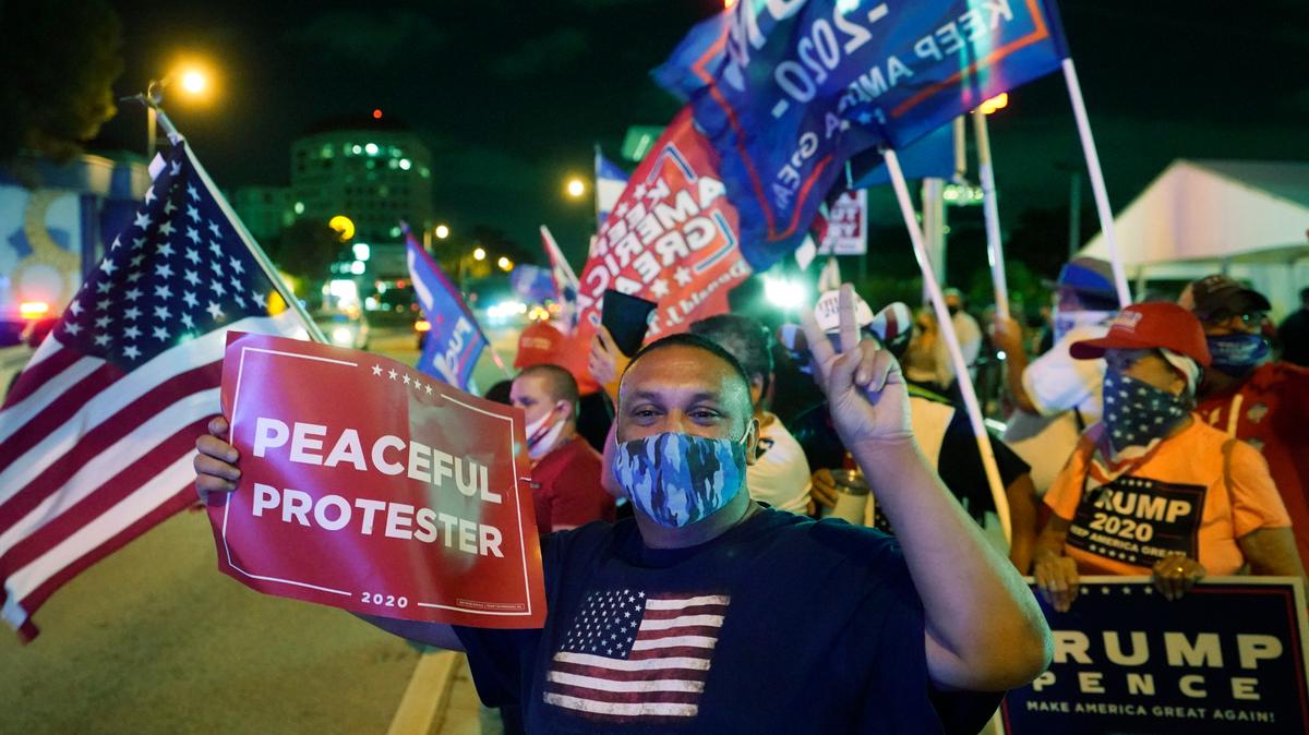 File photo of supporters of President Donald Trump chanting and waving flags outside the Versailles Cuban restaurant during an election night celebration on Nov. 3, 2020, in Miami