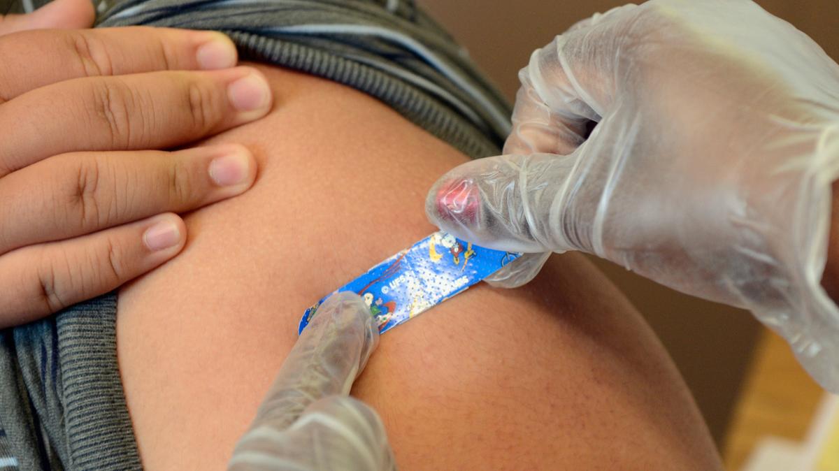 A student receives a vaccine against whooping cough, also called Tdap. 