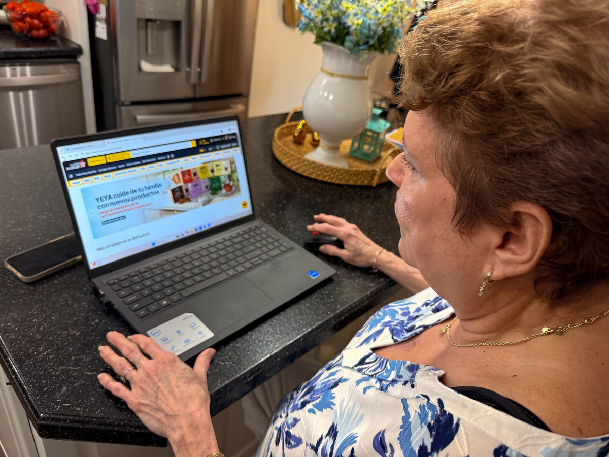 Carmen Deulofeu sits in her kitchen in Louisville with her laptop open to a website that allows her to purchase food that is delivered to relatives in Cuba. 