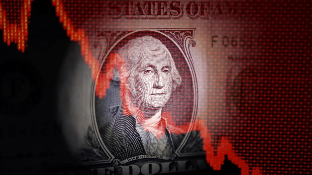 U.S. dollar banknote and decreasing stock graph are seen in this illustration taken April 25, 2025. REUTERS/Dado Ruvic/Illustration