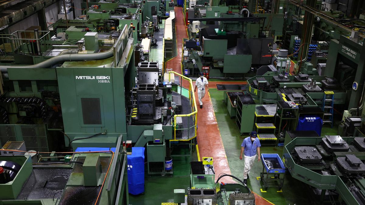 FILE PHOTO: Workers walk between precision-machining machines for automotive parts inside a factory at Kyowa Industrial Co. in Takasaki, Gunma Prefecture, Japan April 11, 2025.  REUTERS/Issei Kato/File Photo