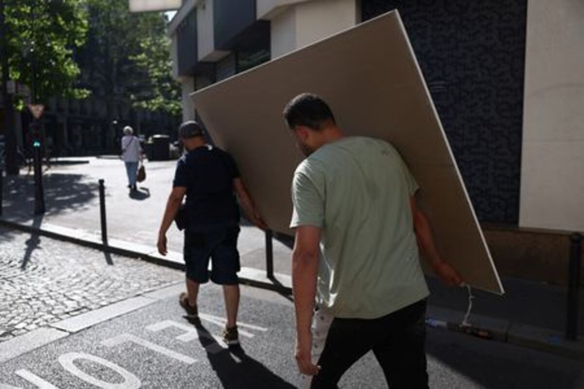 Workers move materials near a construction site in Paris as temperatures rise during a heatwave affecting a large part of France, June 22, 2026. REUTERS/Alice Sacco