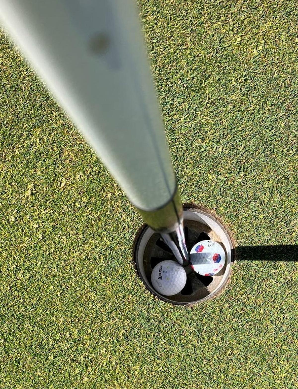  The two golf balls in the hole together. (David Lewis via SWNS) 