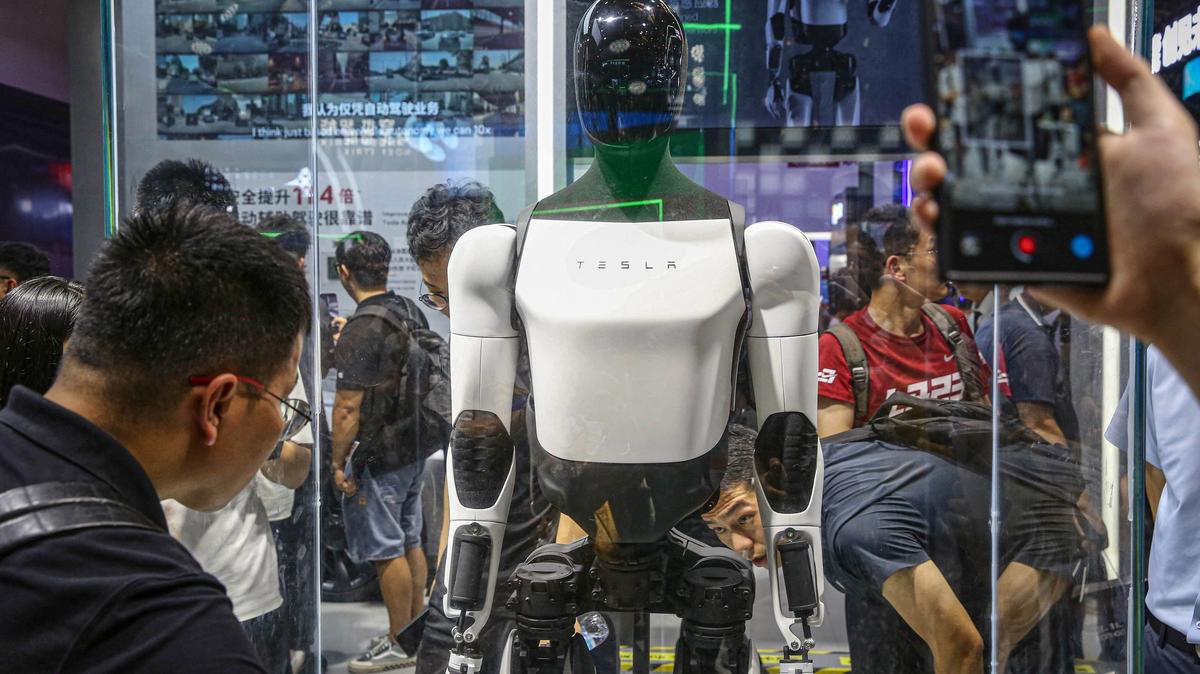 Visitors look at Tesla's humanoid robot Optimus at its exhibition booth during the World Artificial Intelligence Conference in Shanghai on July 5, 2024. (AFP/Getty Images/TNS)