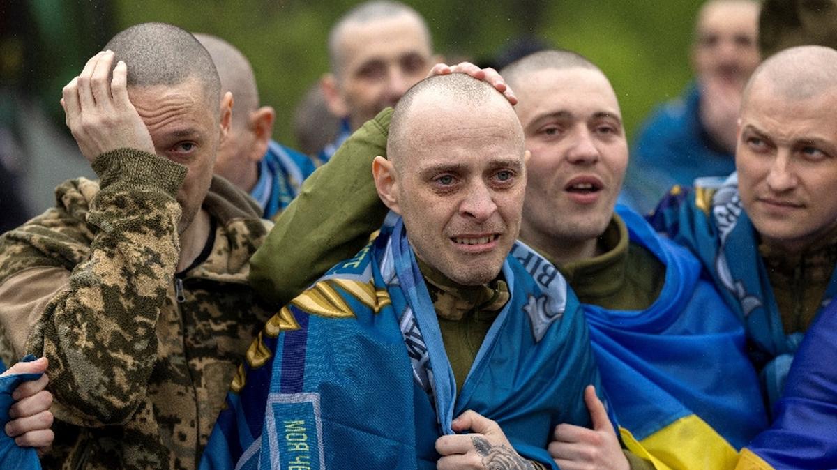 Ukrainian servicemen and former prisoners of war (POW) react after they set foot on Ukrainian soil after a POW swap with Russia, amid Russia's attack on Ukraine, at an undisclosed location in Ukraine May 15, 2026. REUTERS/Thomas Peter