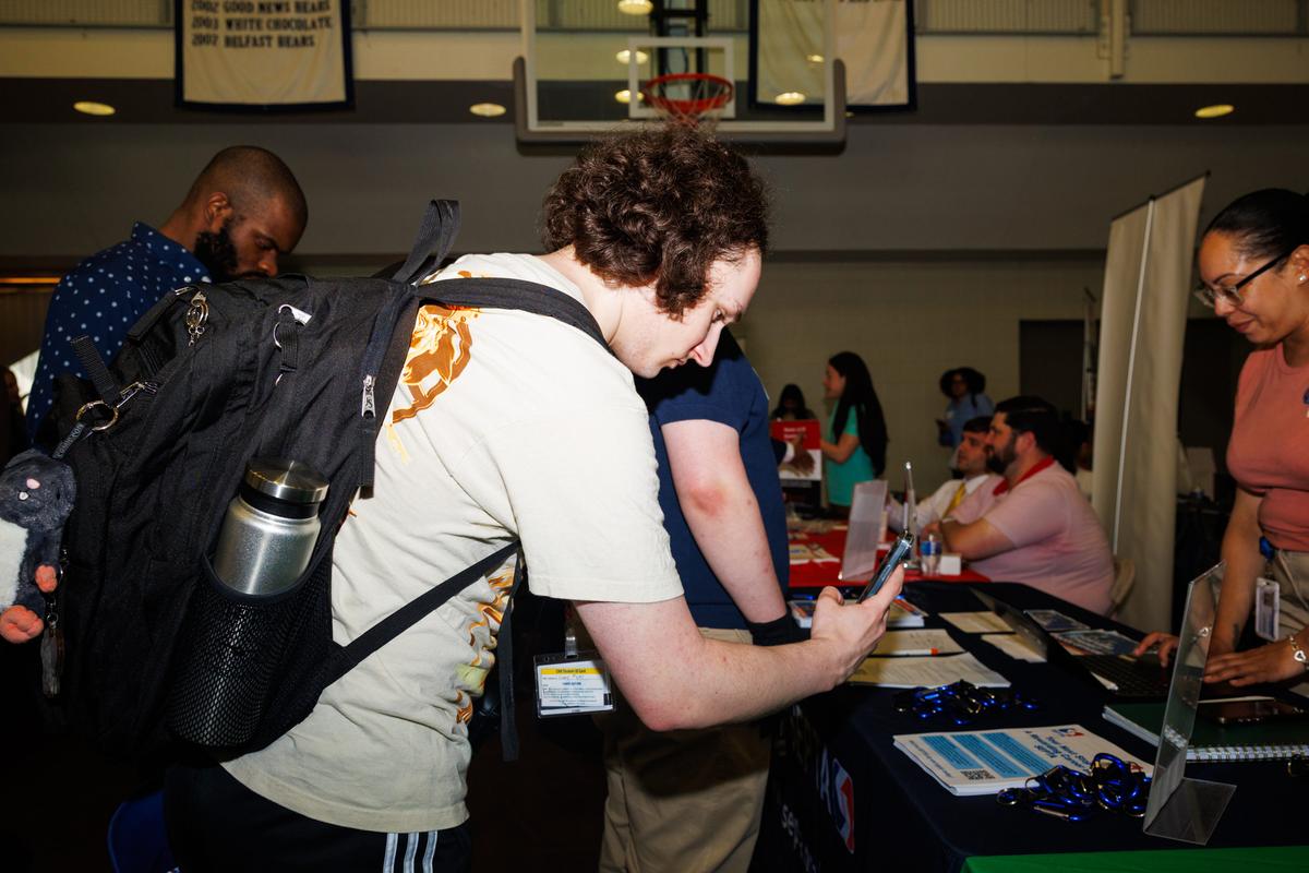  Jimmy Myers, a freshman interested in pursuing a career in transportation, scans a QR code at the Spring Career Fair at Drexel University in Philadelphia. Credit: Hannah Beier for The Hechinger Report