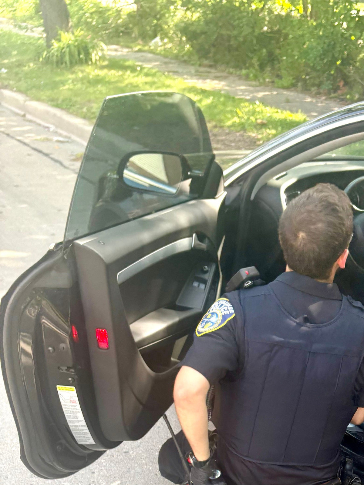 A Milwaukee police officer checks for fingerprints on Journal Sentinel Columnist James E. Causey’s 2012 Black Audi A5 on June 30, 2026. Causey’s car was stolen from downtown near the Milwaukee Area Technical College on June 23. The car was found abandoned near 38th and Stark Streets.